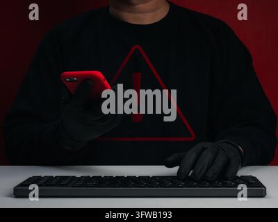 Cybercriminal using smartphone and keyboard with red warning symbol. Mobile account takeover, unauthorized access, compromised credentials, hacking, c Stock Photo