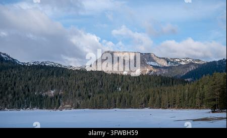 Frozen Black Lake and Majestic Limestone Mountains in Durmitor National Park, Montenegro Stock Photo