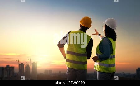 Two construction professionals wearing reflective vests and hard hats ...