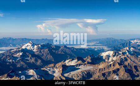 Stunning aerial view of snow capped mountains under blue sky Stock Photo