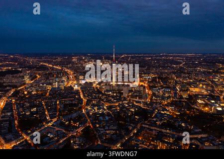 Nighttime aerial perspective of berlin's dynamic cityscape, featuring brightly lit fernsehturm, busy streets, and traffic flowing amidst impressive Stock Photo