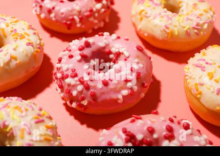 Glazed colored donuts on pink background, close up Stock Photo