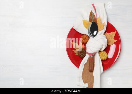 Spoon in white towel on plate, leaves and pumpkins on white background, space for text Stock Photo