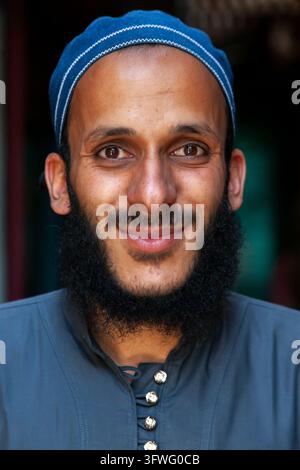 Portrait of a smiling bearded young man wearing a blue skullcap, Jammu and Kashmir, Srinagar, India Stock Photo