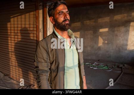 Bearded man standing in an empty shop in warm evening light, Jammu and Kashmir, Srinagar, India Stock Photo