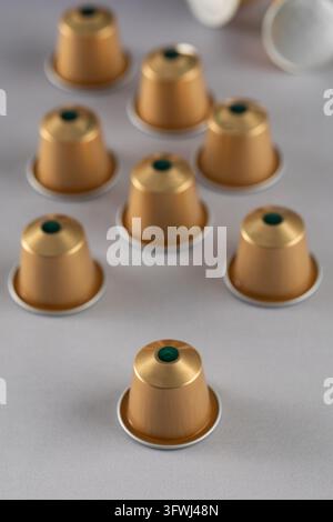 gold coffee capsules arranged on a neutral background, showcasing their sleek and modern design. Ideal for coffee lovers and advertising purposes. Stock Photo