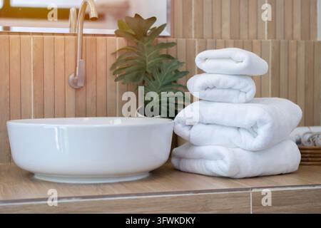 Stack of white clean towels on  on countertop with stylish mirror and vessel sink in bathroom. Space for text Stock Photo