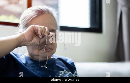 Close up of unhealthy elderly woman take off glasses massage eyes suffering from strong migraine or headache, unwell sick senior female grandmother st Stock Photo