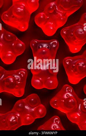 Red gummy bear candy on red background pattern top view macro Stock Photo
