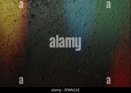 Abstract black background featuring vibrant multicolored highlights that create a striking contrast against the dark surface. The luminous accents add Stock Photo