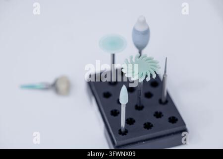 Assorted rotary dental burs arranged in a holder for precision milling, polishing, and fabrication work in prosthetic dentistry laboratories. Stock Photo