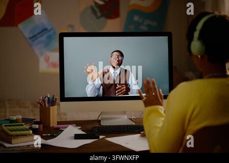 Teenager Having Online Lesson with Black Male Teacher via Computer Stock Photo