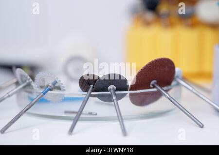 Dental rotary burs and abrasive discs arranged in a laboratory setting for prosthetic milling, polishing, shaping, and finishing applications. Stock Photo