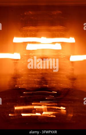 Abstract orange light painting created with long exposure photography, featuring glowing horizontal trails, energetic motion blur, and a dark atmosphe Stock Photo