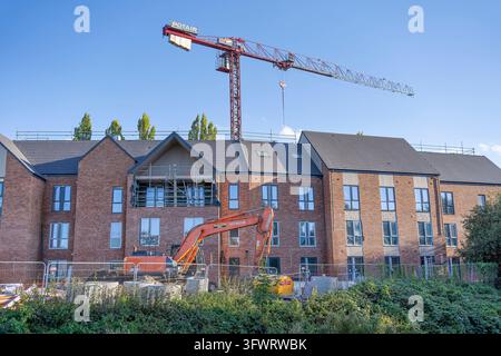 Construction of new build apartment block/ development, UK, with large crane in the background. Stock Photo