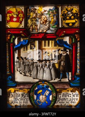 Stained glass panel depicting a procession, heraldic shields and the baptism of Jesus at the Historical Museum of Strasbourg in Alsace, France. Stock Photo
