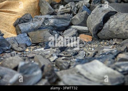 A detailed close view shows irregular black chunks of coal or charcoal piled against coarse burlap fabric as part of the Three Kings Parade displays. Stock Photo