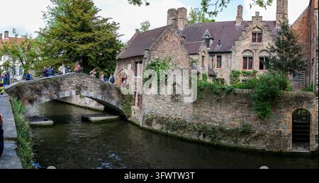 Stone arched bridge, Bonifazius Bridge over canal with some visitors standing on it and behind it historic brick houses with stepped gables, sprout wi Stock Photo