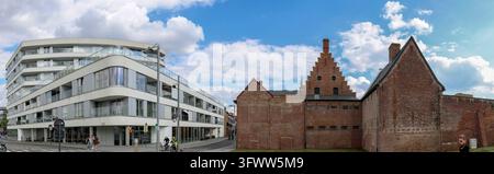 Panoramic view of Budastraat street, with a modern white residential building with curved facade, large windows and surrounding balconies on the left Stock Photo