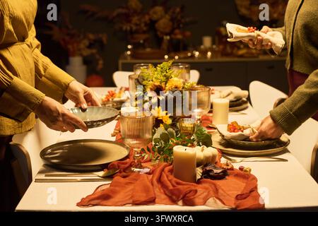 Women Setting Festive Autumn Table for Thanksgiving Celebration Stock Photo
