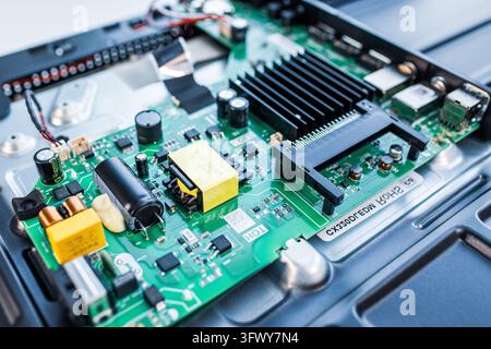 Green circuit board showing various electronic components inside a device Stock Photo
