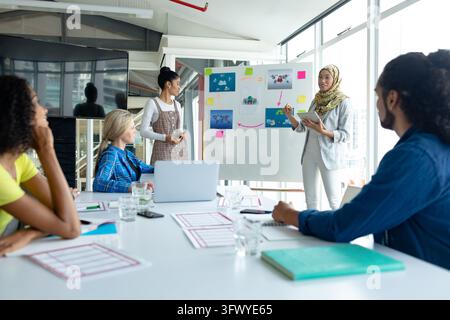 Diverse group of college students listening to senior colleague Stock Photo