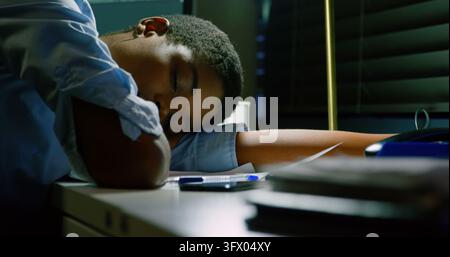 Young African American woman rests at her office desk, with copy space Stock Photo