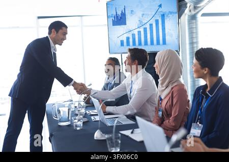 Business people shaking hands with each other while checking in business seminar Stock Photo