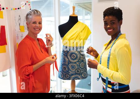 Happy female fashion designers standing together in design studio Stock Photo