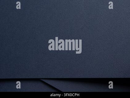 Navy paper texture, dark blue folded sheets with diagonal crease and layered fold. Matte surface close up, indigo background with shadow and grain. El Stock Photo