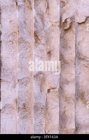 Aged stone texture featuring vertical flutes and worn details, creating an abstract background for architectural and historical themes Stock Photo