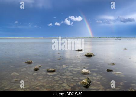 Boulders on beach and two rainbows at Brodtener Ufer / Brodten Steilufer, cliff in the Bay of Lübeck along the Baltic Sea, Schleswig-Holstein, Germany Stock Photo