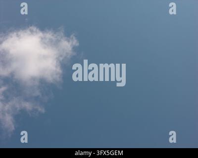 White fluffy cloud floating in clear blue sky Stock Photo