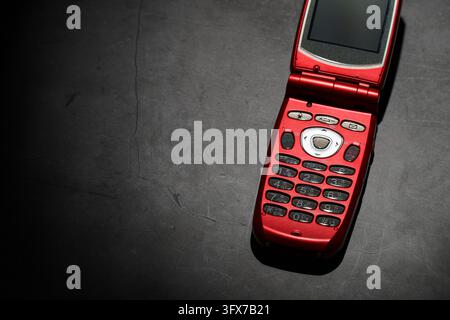 A red flip phone with a physical keypad Stock Photo
