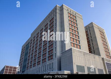 Brooklyn, NY – Sep 4, 2023: Corner view of the MDC Brooklyn federal detention complex with two towers and a lower concrete base under a blue sky. Stock Photo