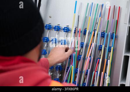Hanover, Germany. 22nd Oct, 2026. ILLUSTRATION - A technician is installing conduit for fiber-optic connections in a distribution box in the Hanover region. Credit: Julian Stratenschulte/dpa/Ģ����ý Live News Stock Photo