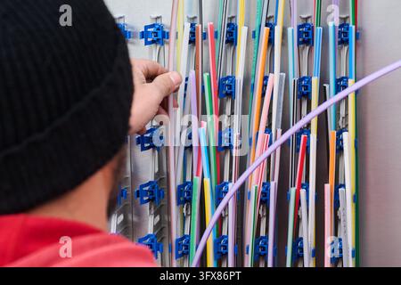 Hanover, Germany. 22nd Oct, 2026. A technician is installing conduit for fiber-optic connections in a distribution box in the Hanover region. Credit: Julian Stratenschulte/dpa/Ģ����ý Live News Stock Photo