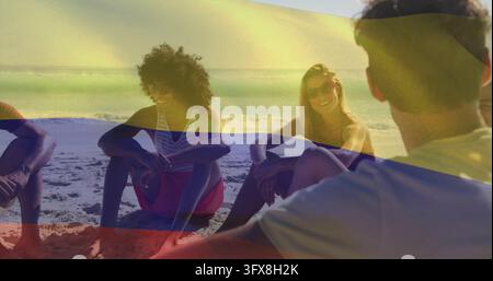 Sitting group of five friends chatting on sandy shore, in swimsuits, sunglasses, with color overlay. Beachgoers, vacation, outdoor, sunshine, oceanfro Stock Photo