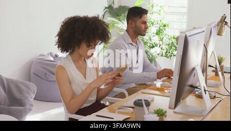 Diverse professionals focused on their tasks in an office. They are engaged in their work, contributing to a productive environment. Stock Photo
