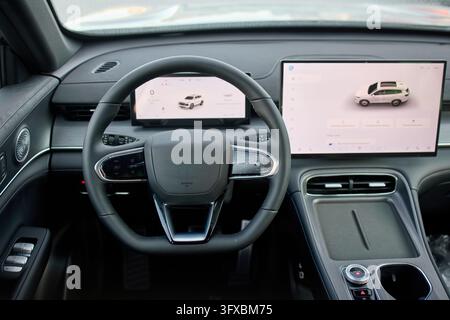 modern and luxurious car interior featuring a sleek steering wheel and dashboard, captured from the passenger seat perspective, highlighting the high- Stock Photo