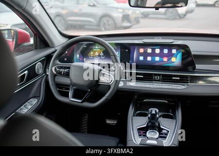 modern and luxurious car interior featuring a sleek steering wheel and dashboard, captured from the passenger seat perspective, highlighting the high- Stock Photo