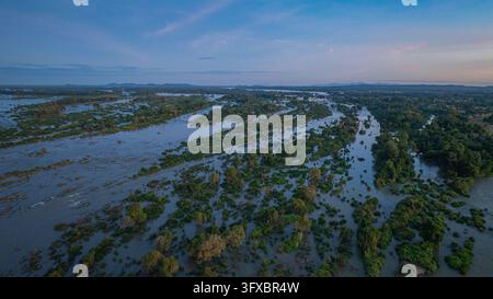 An aerial view shows a sandy beach next to Li Phi Waterfall. a part of the Mekong River in Laos. surrounded by lush greenery, making it a premier natu Stock Photo