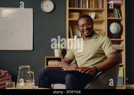 Portrait of Black Male Therapist Taking Notes during Therapy Session Stock Photo