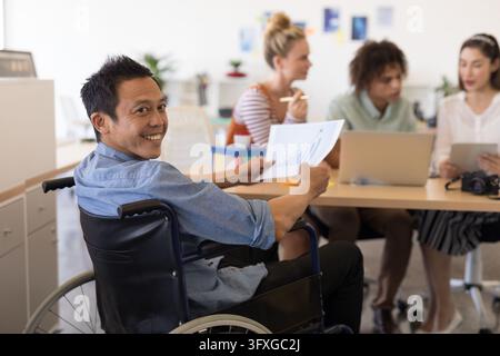 Portrait of disabled Asian male executive holding paper with graph in modern office Stock Photo