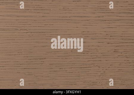 A macro photograph showing the fine horizontal grain and smooth matte finish of a light brown wenge wood veneer panel under natural lighting. Stock Photo