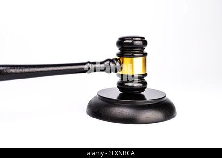 Close-up of a wooden gavel on gray surface, symbolizing law or auction Brown hues dominate with a hint of the handle Isolated perspective Stock Photo