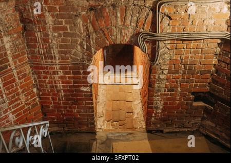 Old brick archway with narrow stone steps in a historic underground passage Stock Photo