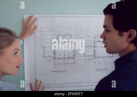 Close-up of Caucasian male and female architects discussing over blueprint in office Stock Photo