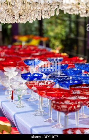 Dining table with tablecloth filled with colorful crystal vintage glasses for luxury event reception Stock Photo