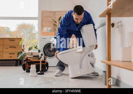 Plumbing repair and home maintenance, professional plumber installing a new toilet in a bathroom renovation project with tools and equipment Stock Photo